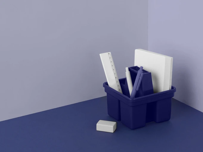 imagem de um porta objetos de escritório todo azul com caneta, papel, régua e borracha todos brancos.