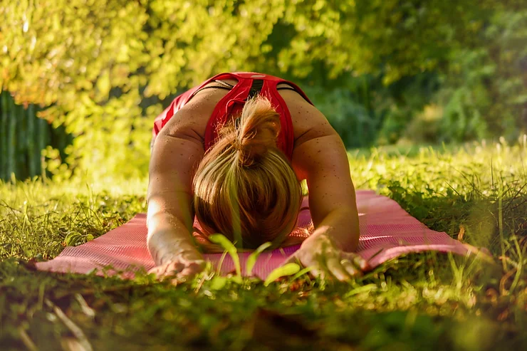 mulher meditando em um parque.