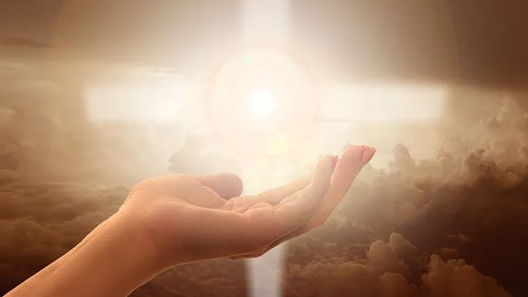 imagem de uma mão esticada com feixe de luz no meio.